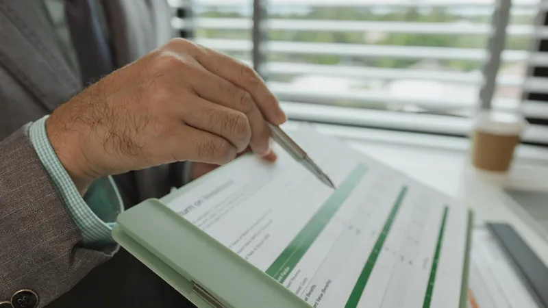 Executive reviewing a printed financial statement with a pen before an earnings release